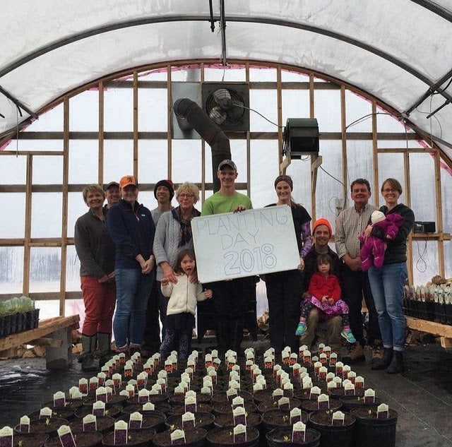 Photo of friends and family with a sign that reads "Planting Day 2018"